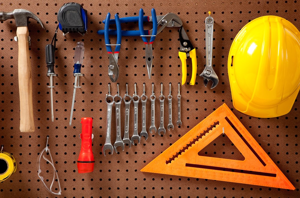 Tools hanging on wall and tool boxes on shelf