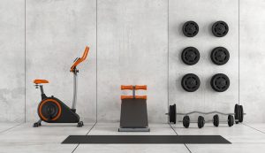 Concrete room with stationary bike, abdominal bench and weight