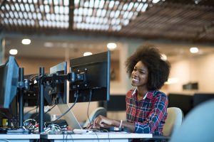 Woman working at multiple monitors